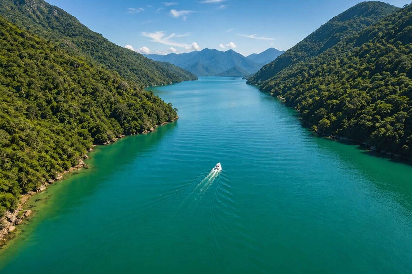 A boat on a turquoise lake surrounded by lush green hills. 4
