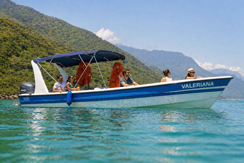 A boat named 'VALERIANA' on calm water with a mountainous backdrop. 1