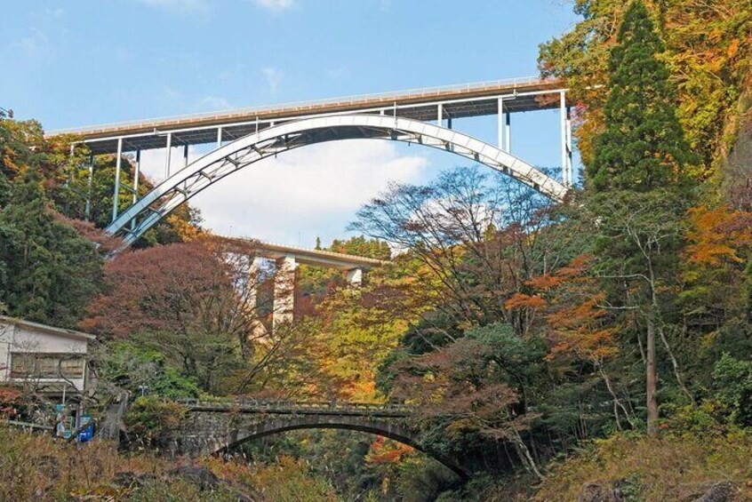 A bridge over a river, surrounded by autumn foliage. 4