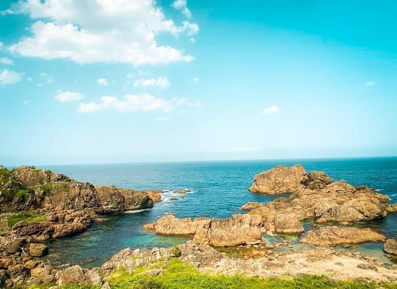 A coastal landscape with rocky formations and clear blue waters. 3