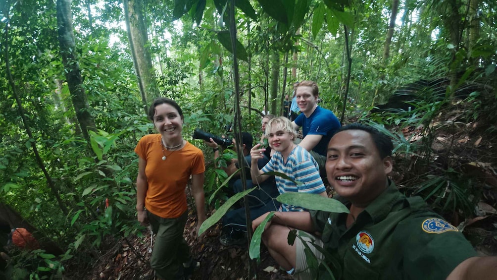 A group of people in a forested area with dense vegetation and trees. 3