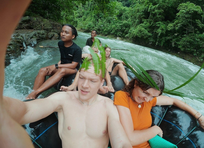 People rafting down a river surrounded by dense greenery. 4