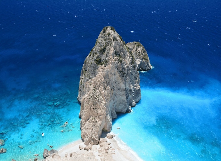 A rocky outcrop surrounded by clear blue waters. 4