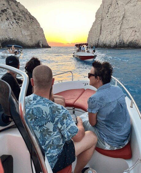 A boat with passengers enjoying a sunset view between rocky cliffs. 2
