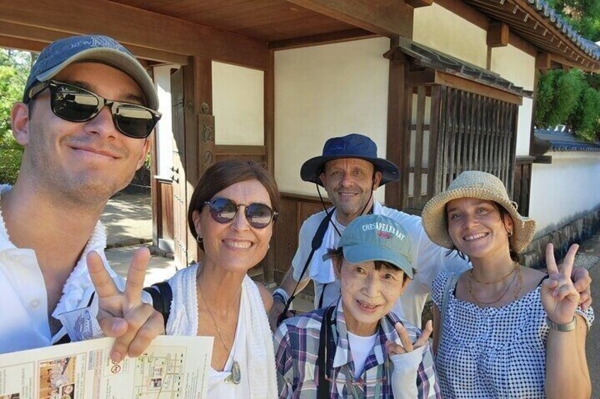 A family posing in front of a traditional Japanese building with wooden architecture. 4