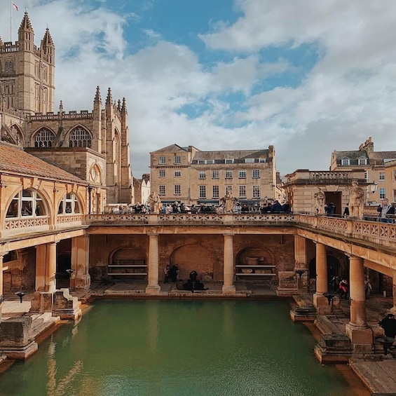 A historic bridge with statues, a large building with towers, and a calm water body. 2