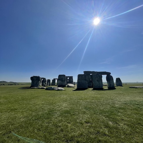 Stonehenge standing in a grassy field under a clear sky. 5
