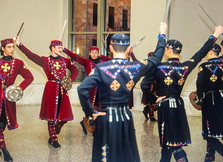 A group of people in traditional costumes performing a dance with swords. 2