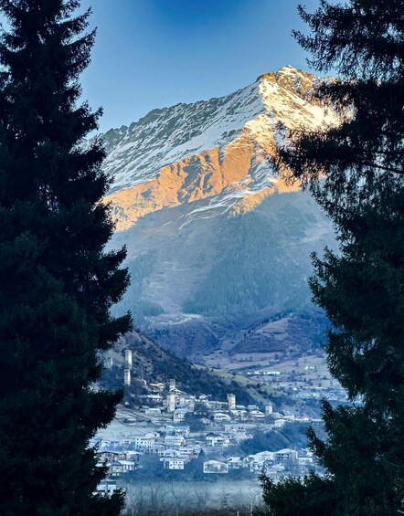 A mountain with snow-covered peaks and a town at its base. 2