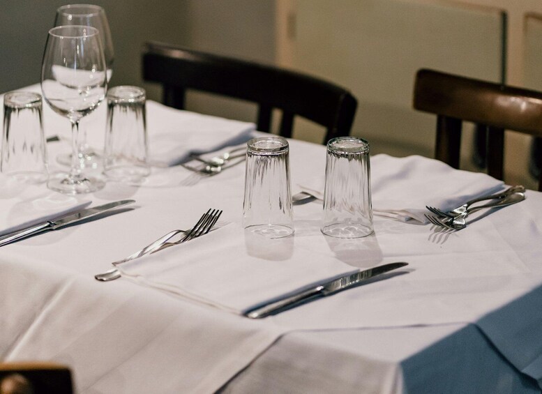 A table set with wine glasses, water glasses, and cutlery. 5