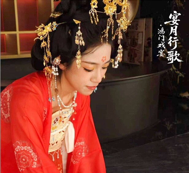 A person in traditional attire with elaborate jewelry and a red garment. 2