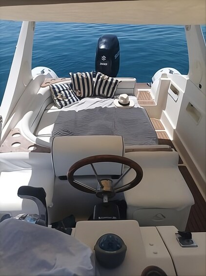 A boat's interior with a steering wheel, cushions, and a Suzuki outboard motor. 3