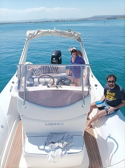 A boat named LOMAC on calm blue waters with a clear sky. 1