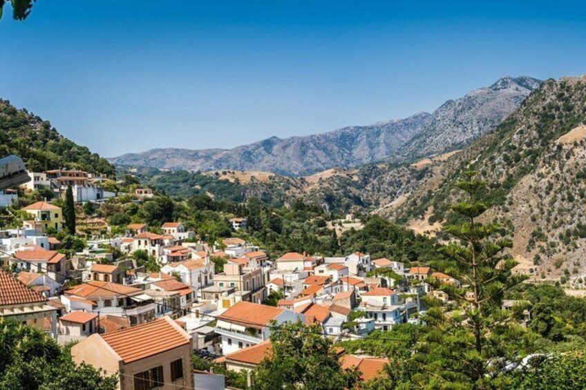A village nestled in a valley with terraced houses and mountains in the background. 5