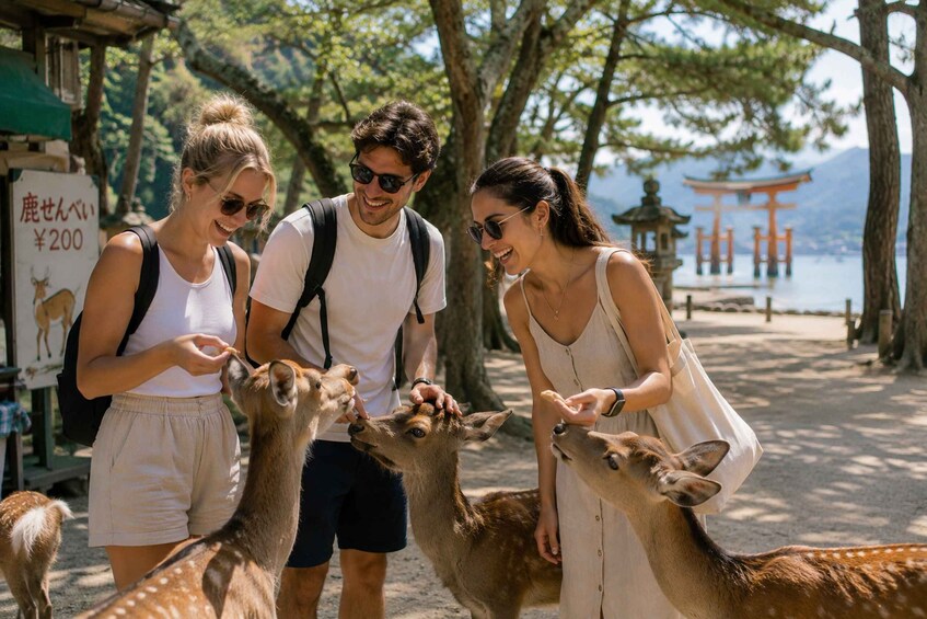 Three people feeding deer in a park with a torii gate and a lake in the background. 5