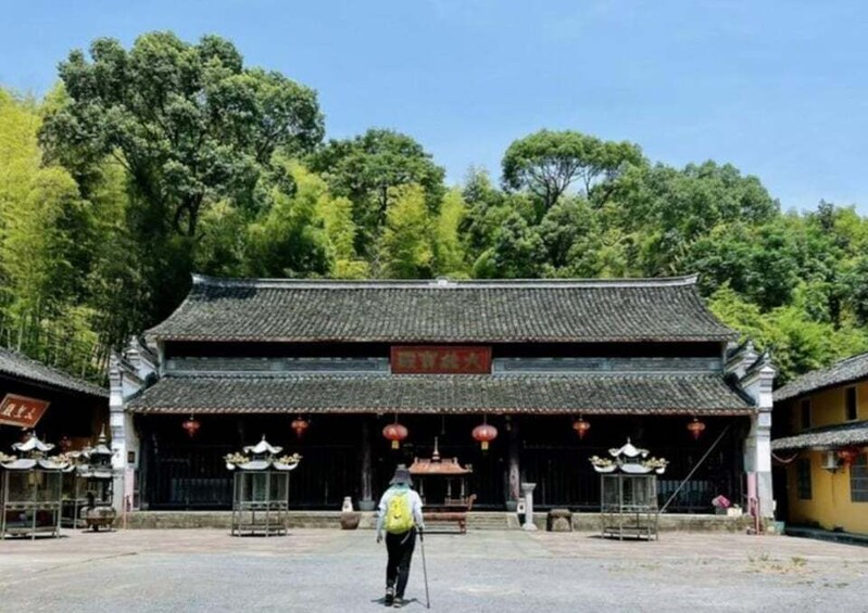 A traditional Chinese building with a tiled roof, surrounded by lush greenery. 5