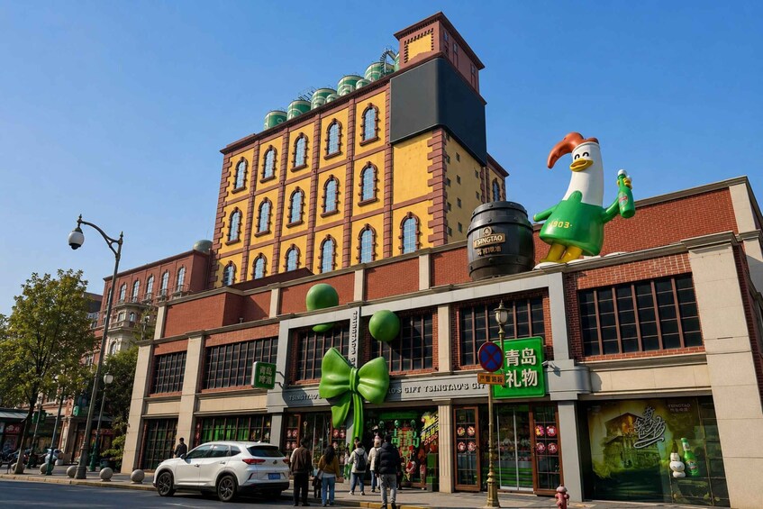 A building with a large green bow decoration, a white car parked in front, and a person walking on the sidewalk. 3