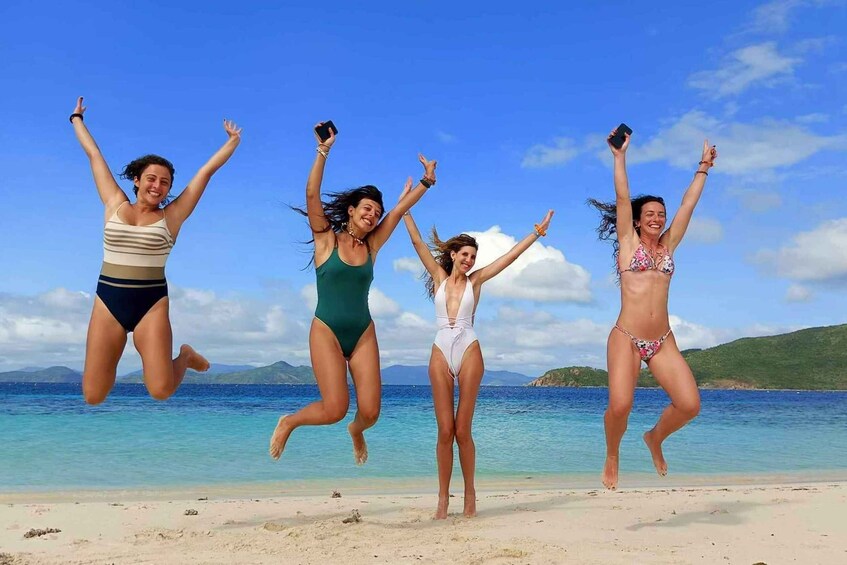 Four people jumping on a beach with a clear sky and calm sea. 1