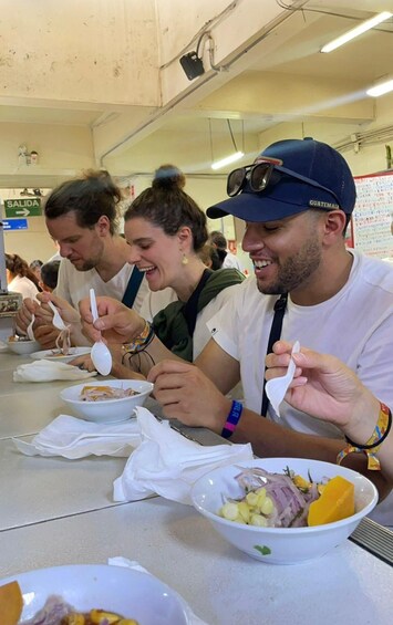 People eating at a cafeteria with bowls of food and spoons. 1