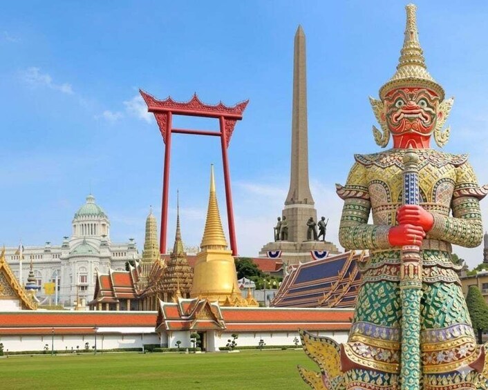A temple with a golden spire, a red gate, and a large statue in front. 1