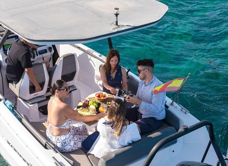 A group of people on a boat with a table of food and drinks. 3