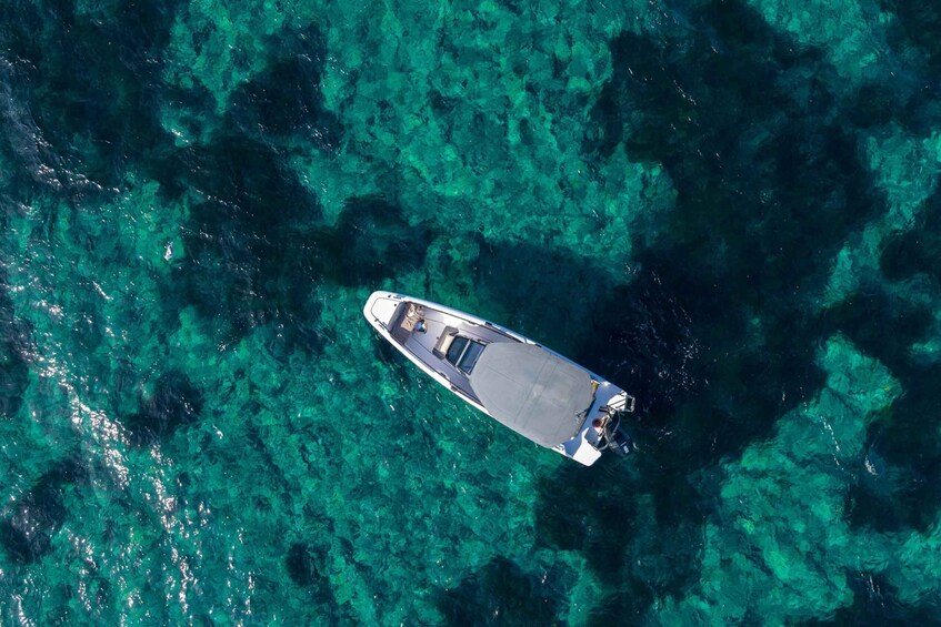 An aerial view of a boat on clear turquoise waters. 2