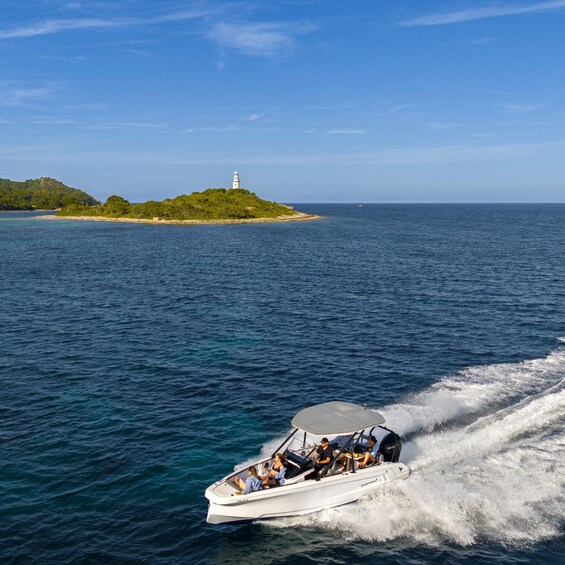 A speedboat with passengers, moving through calm blue waters, with a lighthouse on a green island in the background. 4