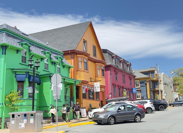 Colorful buildings, a street with cars, and a recycling bin. 2