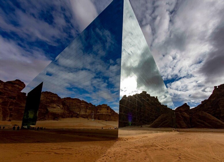 A desert landscape with rock formations and a modern glass structure. 3