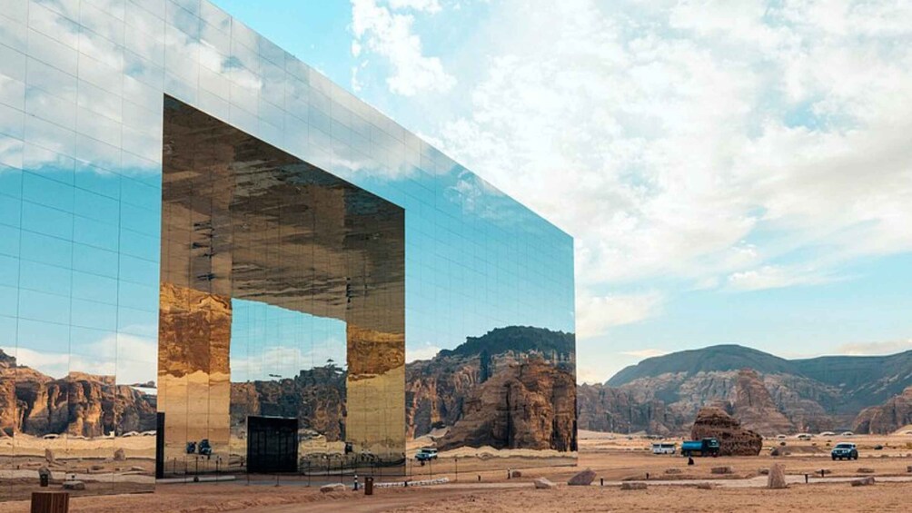 A modern building with a large glass facade reflecting the surrounding desert landscape. 2