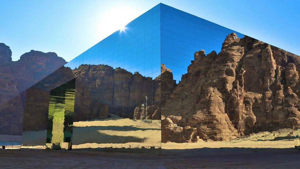 A desert landscape with a modern glass building and rocky formations. 4