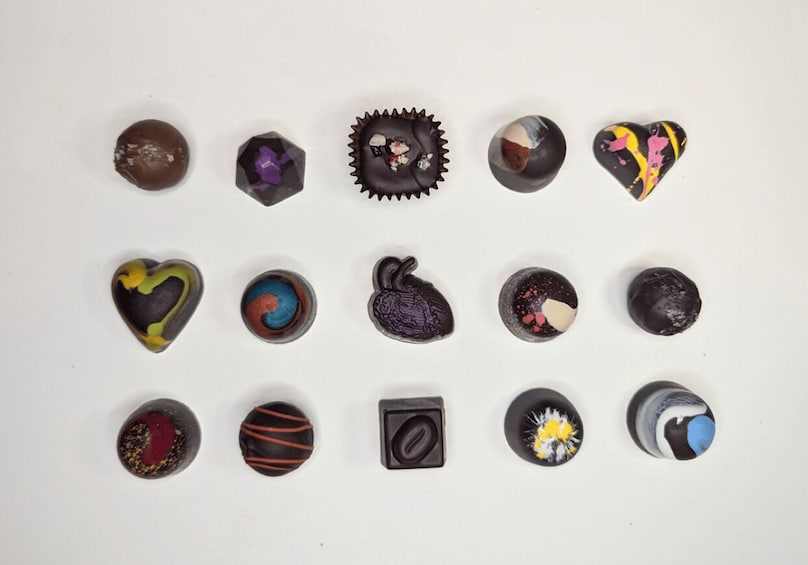 A collection of uniquely shaped and decorated chocolates arranged on a white surface. 5