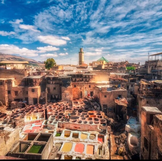 A traditional dyeing area with large vats and a mosque in the background. 2