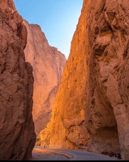 A canyon with towering rock walls and a winding road. 5