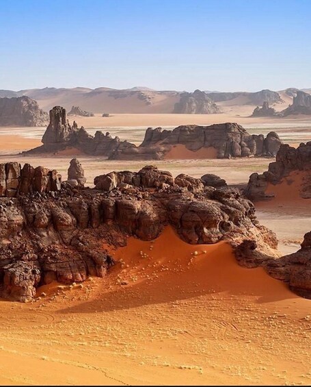 A desert landscape with prominent rock formations and sand dunes. 4