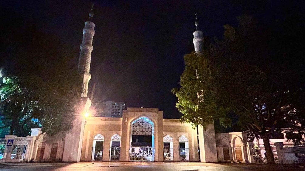 A mosque with two minarets, arched doorways, and a large central entrance. 5