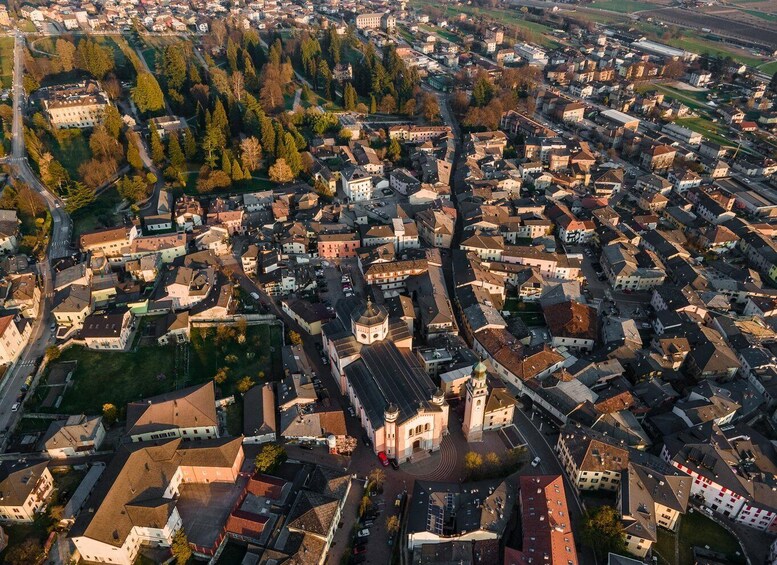 An aerial view of a densely packed town with a prominent church and surrounding greenery. 1