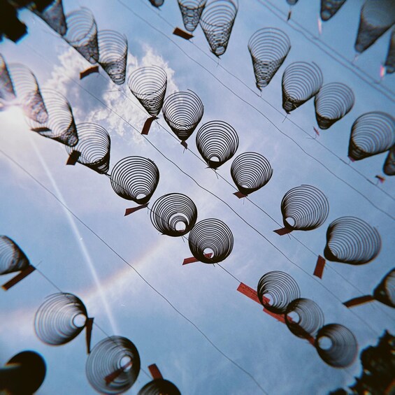 A pattern of traditional paper lanterns arranged in rows against a cloudy sky. 2