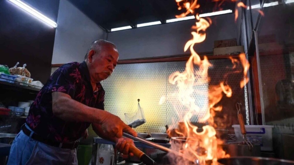 A person cooking with flames. 1