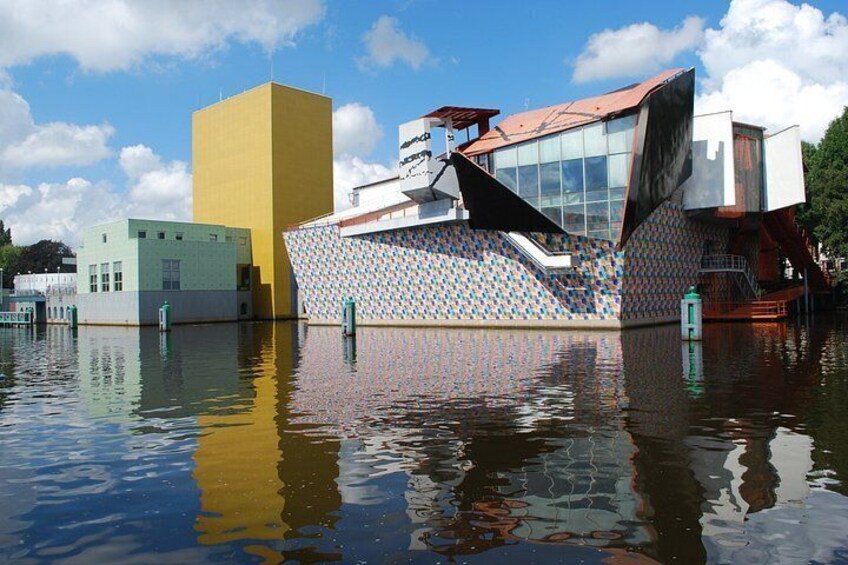 A modern building with a unique design, surrounded by water. 5