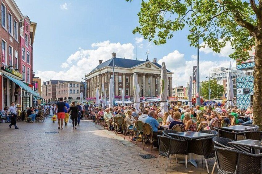 A bustling outdoor café area with people dining and walking. 3