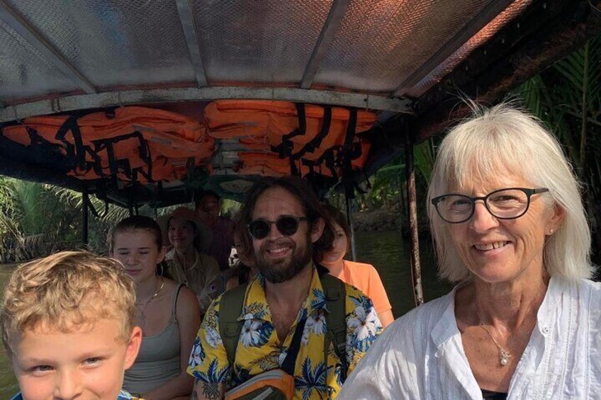 A group of people on a boat with a canopy overhead. 4