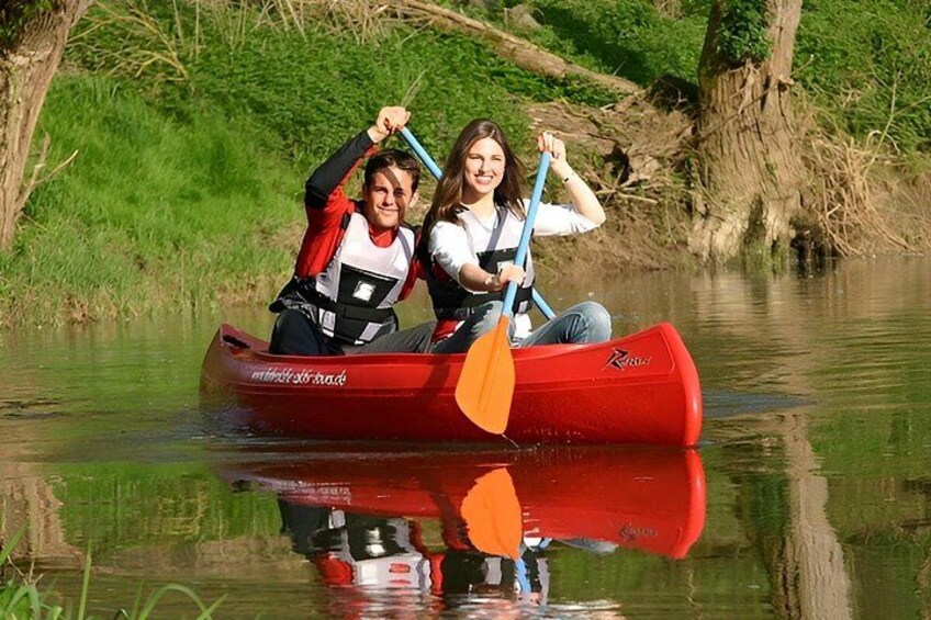 Two people in a red canoe on a calm river. 3