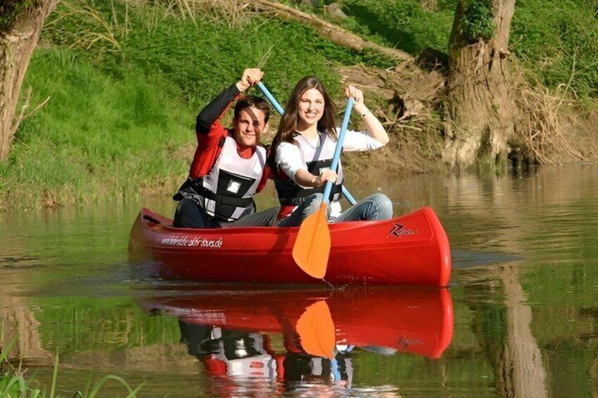 Two people in a red canoe on a calm river. 3