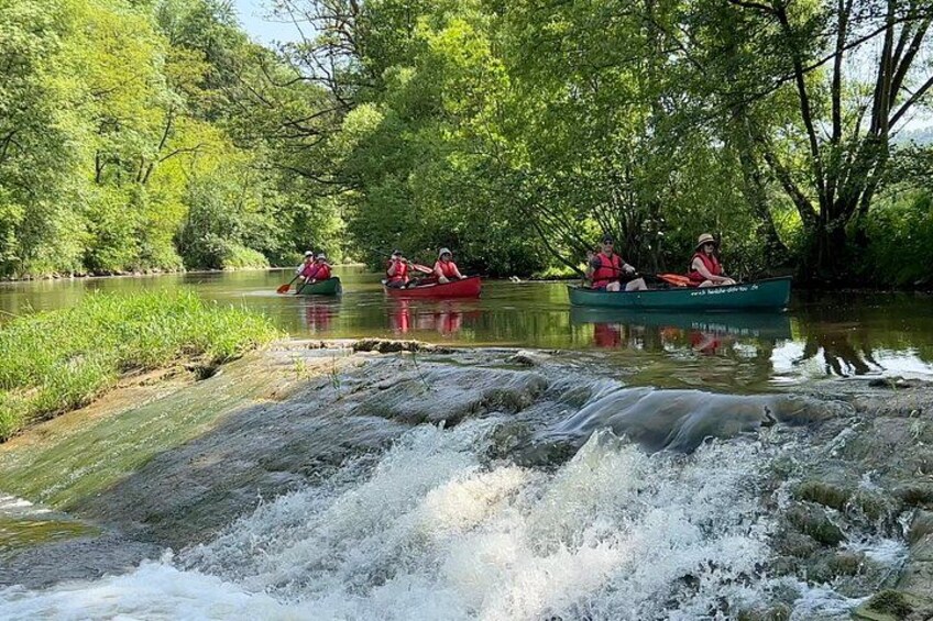 People kayaking on a river surrounded by lush greenery. 4