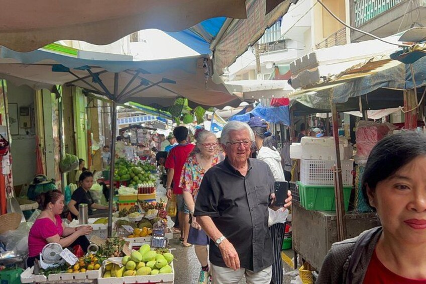 A bustling outdoor market with people shopping and vendors selling fruits and vegetables. 5