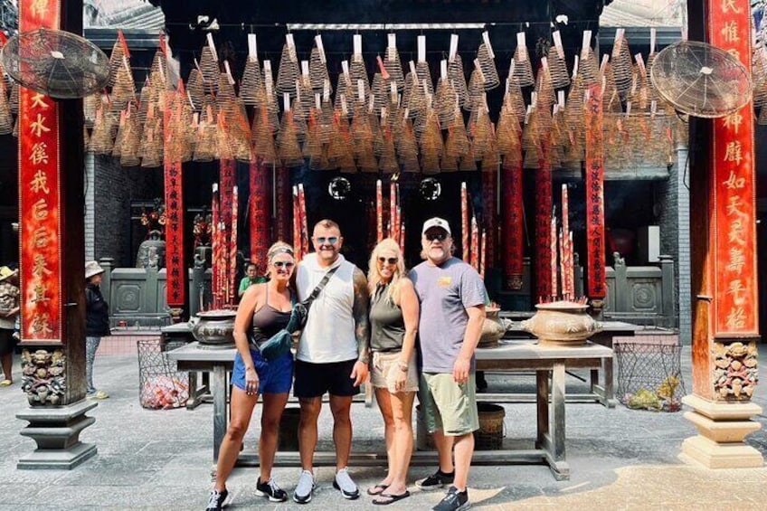 A temple with red pillars and incense burners. 2