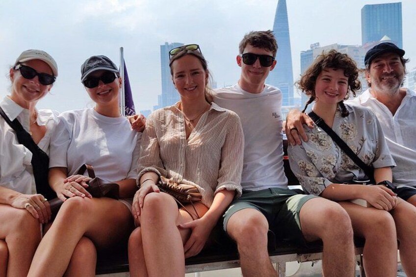 A group of people sitting on a ledge with a city skyline in the background. 4