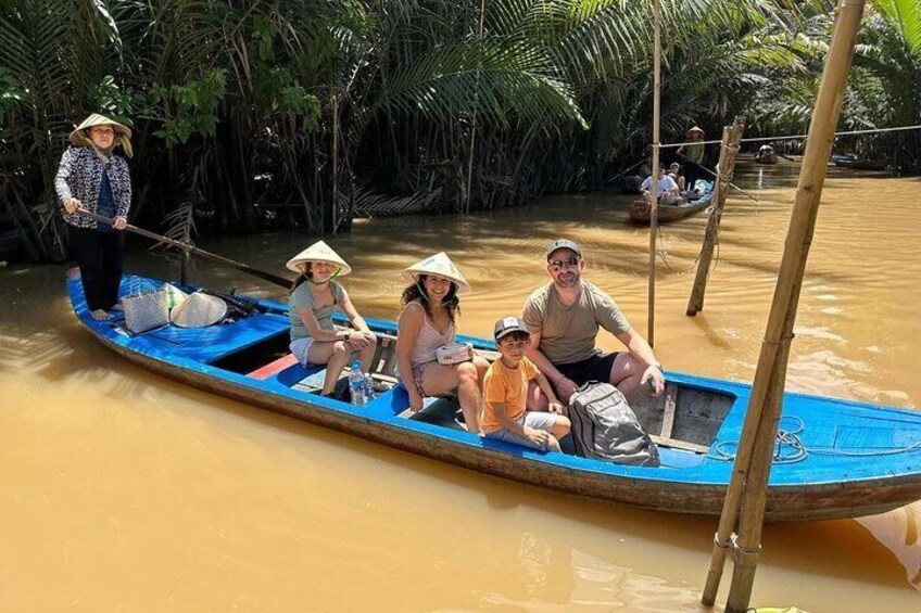 A group of people in a blue boat on a river surrounded by dense greenery. 5