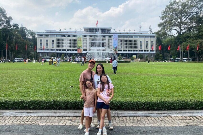 A group of people in front of a large building with a fountain. 2